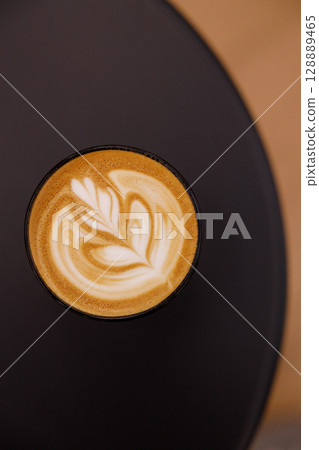 Cup of hot milk latte coffee on table. Cup of hot milk latte coffee on table. 128889465