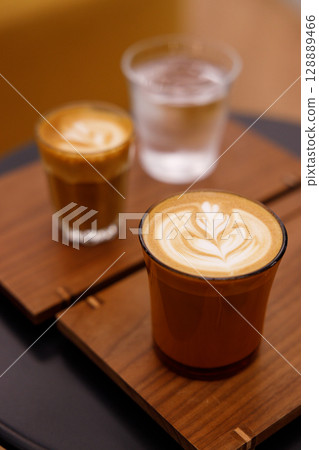 Cup of hot milk latte coffee on table. Cup of hot milk latte coffee on table. 128889466