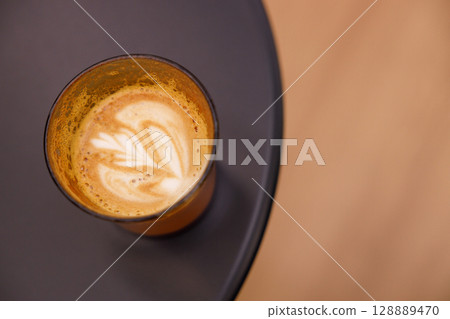 Cup of hot milk latte coffee on table. Cup of hot milk latte coffee on table. 128889470