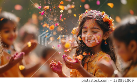 Children in vibrant clothing joyfully tossing flower petals and colored powder 128891809