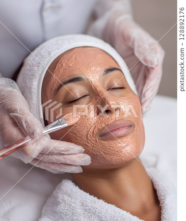 Technician applying warm clay mask 128892176
