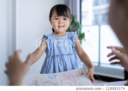 Smiling girl enjoying drawing 128893174