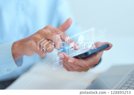Person Using Smartphone With Holographic Credit Card Display for Digital Payments Person Using Smartphone With Holographic Credit Card Display for Digital Payments 128893253