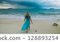 Charming woman with blonde curly long hair walk in beach, in stormy morning rain cloudy sea. Concept resort outdoor relax summer vacation, travel Charming woman with blonde curly long hair walk in beach, in stormy morning rain cloudy sea. Concept resort outdoor relax summer vacation, travel 128893254