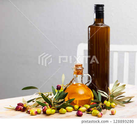 Olive oil in bottles on wooden table 128893280