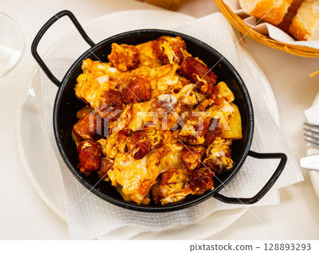 Huevos con chistorra. Scrambled eggs with sausage and potatoes Huevos con chistorra. Scrambled eggs with sausage and potatoes 128893293