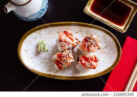 Uramaki sushi rolls with avocado, salmon and unagi sauce 128893380