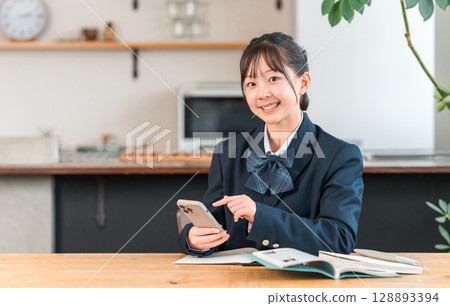 在家用智慧型手機學習、家庭作業、在客廳學習的國中生、高中生、小學生、女學生 128893394