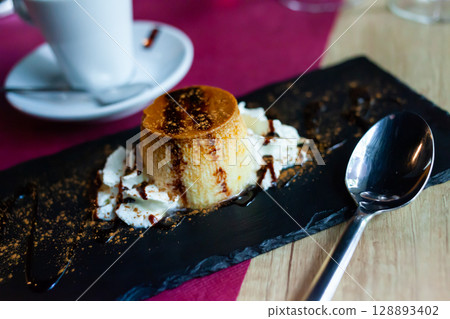 Portion of fresh flan with cream on serving board Portion of fresh flan with cream on serving board 128893402