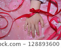 Close-up of a child's small hand with a ribbon tied around it 128893600