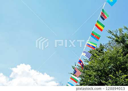 在炎熱夏日的天空下，各國國旗飄揚 128894013