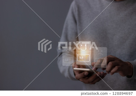 Review Customer, Young Man hand using smartphone mobile with five star to review and give 5 stars Review Customer, Young Man hand using smartphone mobile with five star to review and give 5 stars 128894697