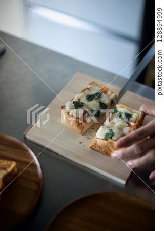 Cutting the baked pizza toast 128894999