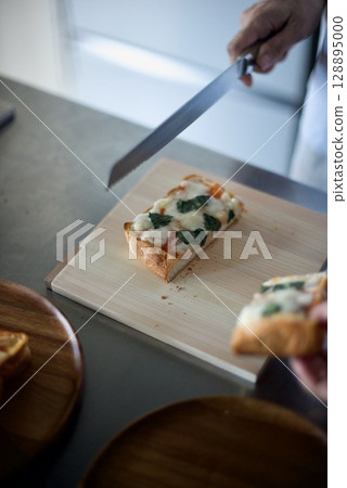 Cutting the baked pizza toast Cutting the baked pizza toast 128895000