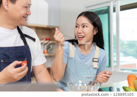 Joyful Cooking: Couple Enjoying Healthy Meal Prep in Bright Kitchen 128895105