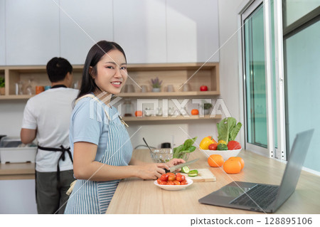Cooking Together: Woman Smiling While Preparing Fresh Vegetables 128895106