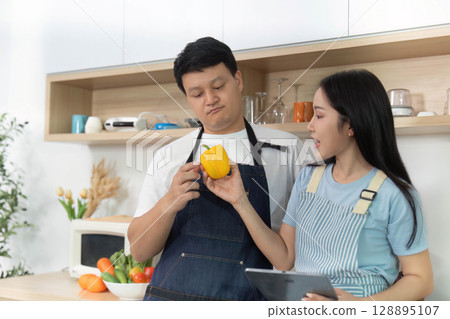 Healthy Cooking: Couple Discussing Ingredients in Bright Kitchen 128895107