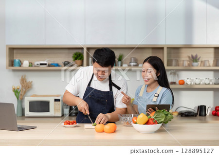 Cooking Class: Couple enjoying meal prep with fresh ingredients 128895127