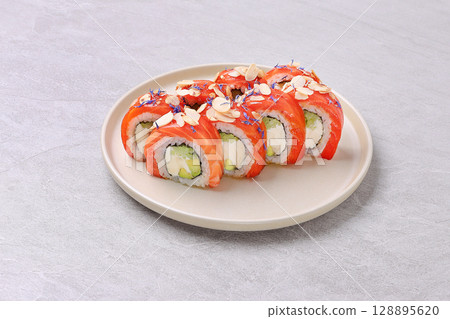 Salmon and Almond Sushi Roll with Avocado and Cream Cheese on Stone Plate 128895620