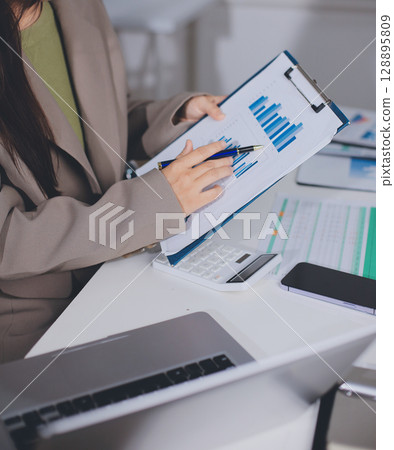 Portrait of young Hispanic professional business woman standing in office. Happy female company executive, smiling businesswoman entrepreneur corporate leader manager looking at camera using tablet 128895809