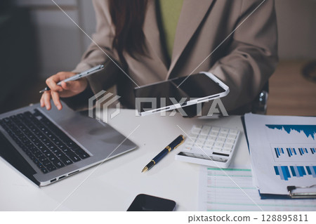 Portrait of young Hispanic professional business woman standing in office. Happy female company executive, smiling businesswoman entrepreneur corporate leader manager looking at camera using tablet Portrait of young Hispanic professional business woman standing in office. Happy female company executive, smiling businesswoman entrepreneur corporate leader manager looking at camera using tablet 128895811