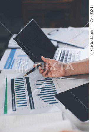 Portrait of young Hispanic professional business woman standing in office. Happy female company executive, smiling businesswoman entrepreneur corporate leader manager looking at camera using tablet 128895815