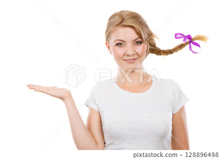 Happy teenage girl in braid hair presenting hand Happy teenage girl in braid hair presenting hand 128896498