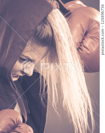 Angry woman wearing boxing gloves 128896756