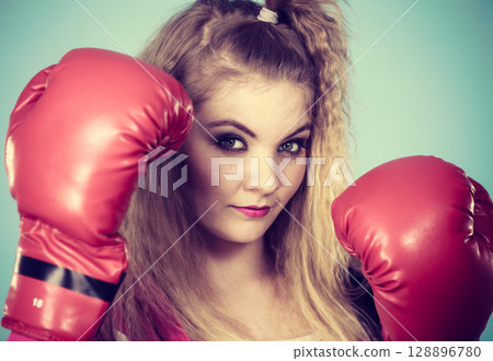 Cute girl in red gloves playing sports boxing Cute girl in red gloves playing sports boxing 128896780