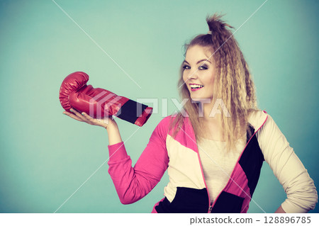 Funny girl in red gloves playing sports boxing 128896785