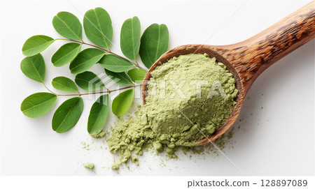 Close-up of moringa powder in a wooden spoon with fresh leaves 128897089