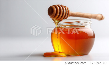 Rich raw honey dripping from a honey dipper 128897100