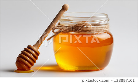 木棍和玻璃罐中的金黃色生蜂蜜 木棍和玻璃罐中的金黃色生蜂蜜 128897101