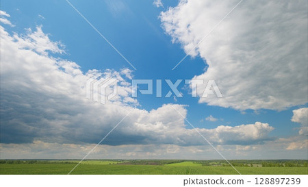 The Serene Sky is Beautifully Lined with Fluffy Clouds Over Lush Green Expansive Fields 128897239