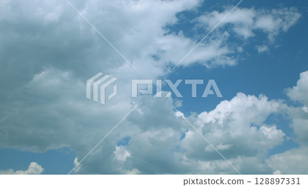 The dynamic and everchanging cloudy skies gracefully hover over a beautiful blue background 128897331