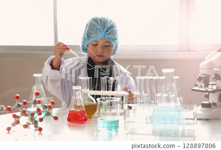 Kid and science. Child dress scientist learning conducts experiment in lab with colorful chemicals test tubes and molecular models. Inspiring early STEM education science learning and curiosity in kid Kid and science. Child dress scientist learning conducts experiment in lab with colorful chemicals test tubes and molecular models. Inspiring early STEM education science learning and curiosity in kid 128897806