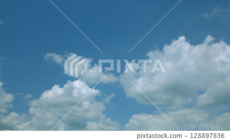 A beautifully adorned cloudy sky filled with fluffy clouds on an exquisitely bright and sunny day A beautifully adorned cloudy sky filled with fluffy clouds on an exquisitely bright and sunny day 128897836