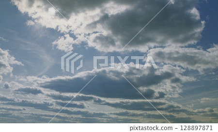 Explore the Dynamic Cloudscapes Set in a Beautifully Vibrant Sky Over the Earth Today 128897871