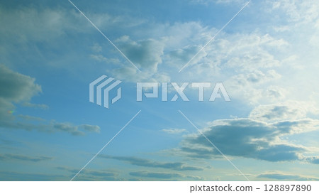 A beautiful composition of a tranquil blue sky adorned with fluffy white clouds A beautiful composition of a tranquil blue sky adorned with fluffy white clouds 128897890