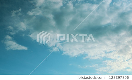 A Beautiful, Serene Blue Sky with Fluffy White Clouds Gracefully Floating Above in Calm Harmony A Beautiful, Serene Blue Sky with Fluffy White Clouds Gracefully Floating Above in Calm Harmony 128897896