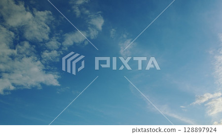 A Beautiful Clear Blue Sky with Soft Clouds Above An Enchanting and Peaceful Natural Scene A Beautiful Clear Blue Sky with Soft Clouds Above An Enchanting and Peaceful Natural Scene 128897924