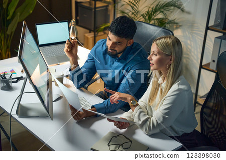 Team of Professionals Collaborating on Project in Modern Office Displaying Productivity and Focus 128898080