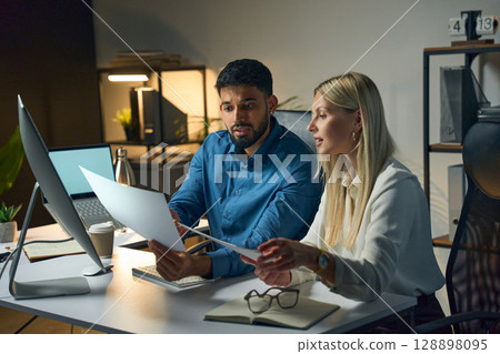 Two Colleagues Working Together in a Modern Office on a Project Document Review 128898095