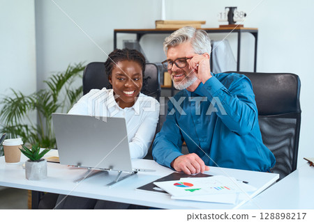 Two Professionals Collaborating on a Project in a Modern Office Environment 128898217