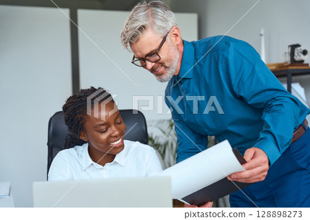 Friendly Office Collaboration Between Colleagues Reviewing Documents and Discussing Project Details 128898273