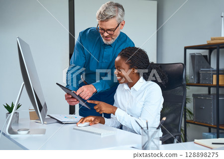 Professional Team Collaborating in Modern Office Environment with Digital Devices and Documents 128898275