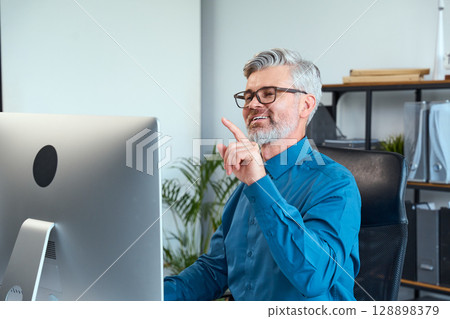 Experienced Professional Communicating Ideas While Working at a Modern Office Desk Experienced Professional Communicating Ideas While Working at a Modern Office Desk 128898379