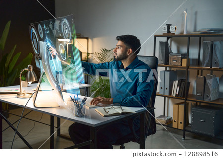 Man Using Advanced Holographic Interface In Modern Office Environment 128898516