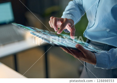 Professional Using Futuristic Digital Transparent Tablet in a Modern Office Environment Professional Using Futuristic Digital Transparent Tablet in a Modern Office Environment 128898553