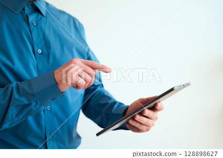 Professional Using Touchscreen Device for Business or Technology Communication Concept 128898627